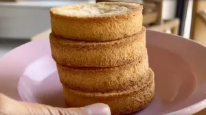 Gros plan sur une pile de palets bretons dorés, épais et croustillants, posés sur une assiette rose