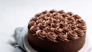 Charlotte au chocolat garnie de mousse fondante, décorée de chantilly au cacao sur assiette blanche.